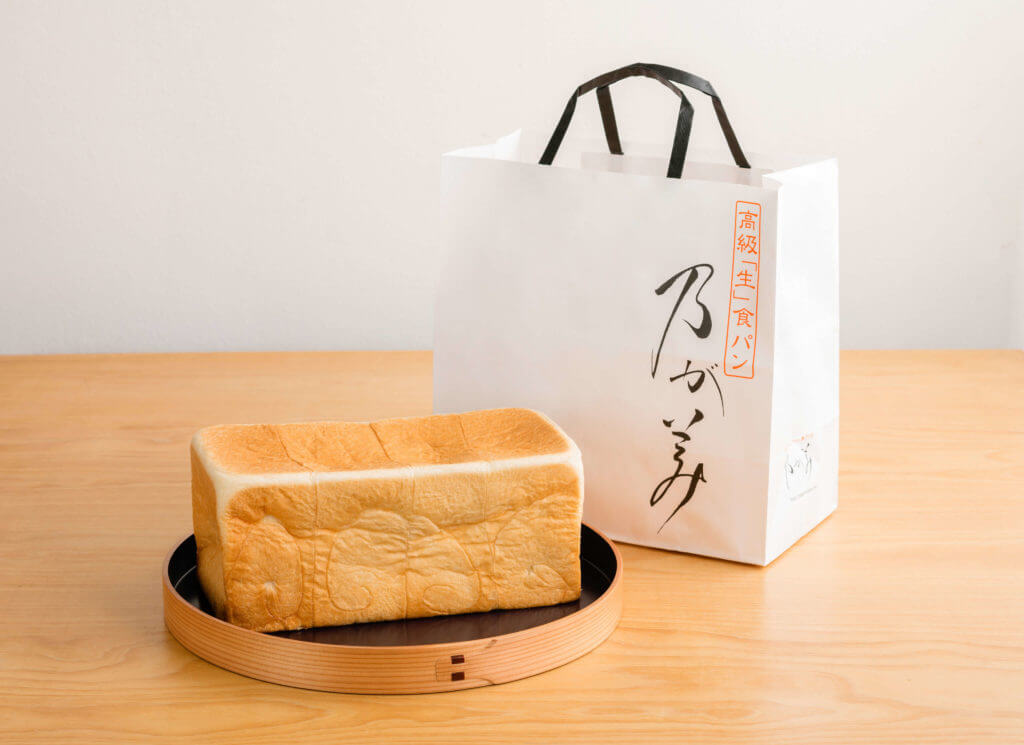 高級「生」食パン専門店 乃が美の紙袋とパン